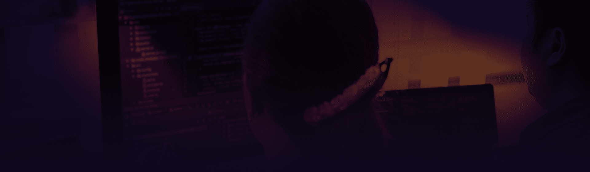 Gradient overlay on top of a woman sitting at a computer monitor.
